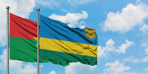Burkina Faso and Rwanda flag waving in the wind against white cloudy blue sky together. Diplomacy concept, international relations.