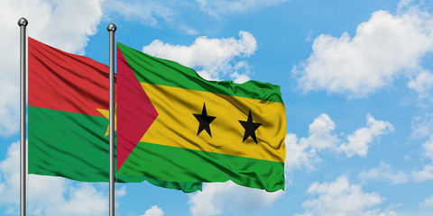 Burkina Faso and Sao Tome And Principe flag waving in the wind against white cloudy blue sky together. Diplomacy concept, international relations.