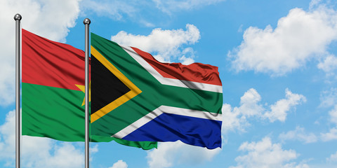 Burkina Faso and South Africa flag waving in the wind against white cloudy blue sky together. Diplomacy concept, international relations.