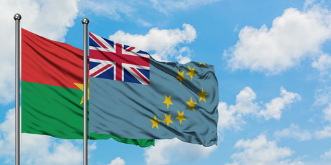 Burkina Faso and Tuvalu flag waving in the wind against white cloudy blue sky together. Diplomacy concept, international relations.