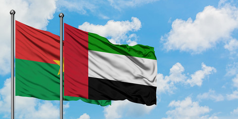 Burkina Faso and United Arab Emirates flag waving in the wind against white cloudy blue sky together. Diplomacy concept, international relations.