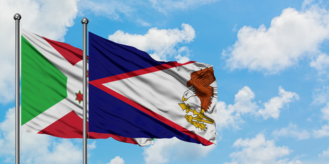 Burundi and American Samoa flag waving in the wind against white cloudy blue sky together....