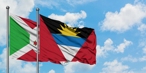 Burundi and Antigua and Barbuda flag waving in the wind against white cloudy blue sky together. Diplomacy concept, international relations.