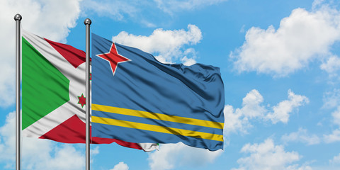 Burundi and Aruba flag waving in the wind against white cloudy blue sky together. Diplomacy concept, international relations.