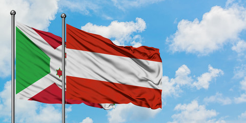 Burundi and Austria flag waving in the wind against white cloudy blue sky together. Diplomacy concept, international relations.