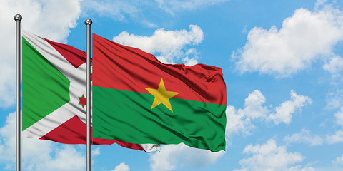 Burundi and Burkina Faso flag waving in the wind against white cloudy blue sky together. Diplomacy concept, international relations.