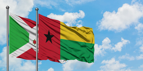 Burundi and Guinea Bissau flag waving in the wind against white cloudy blue sky together. Diplomacy concept, international relations.