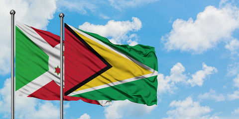 Burundi and Guyana flag waving in the wind against white cloudy blue sky together. Diplomacy concept, international relations.