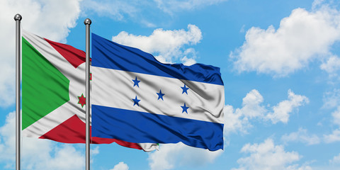 Burundi and Honduras flag waving in the wind against white cloudy blue sky together. Diplomacy...
