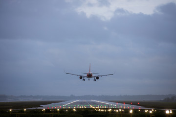 Airplane landing on the runway in the evening