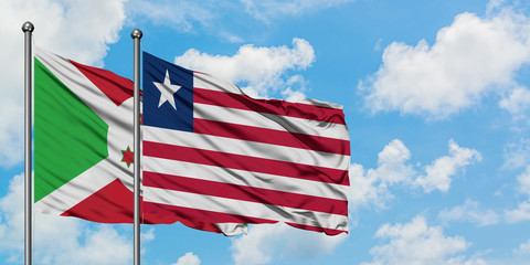 Burundi and Liberia flag waving in the wind against white cloudy blue sky together. Diplomacy concept, international relations.