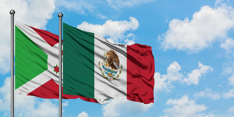 Burundi and Mexico flag waving in the wind against white cloudy blue sky together. Diplomacy concept, international relations.