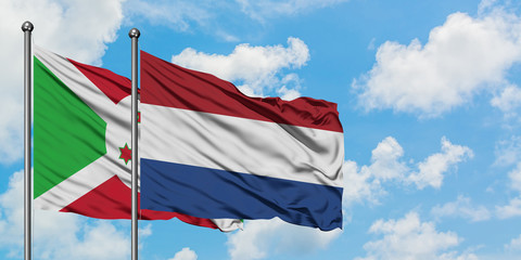 Burundi and Netherlands flag waving in the wind against white cloudy blue sky together. Diplomacy concept, international relations.