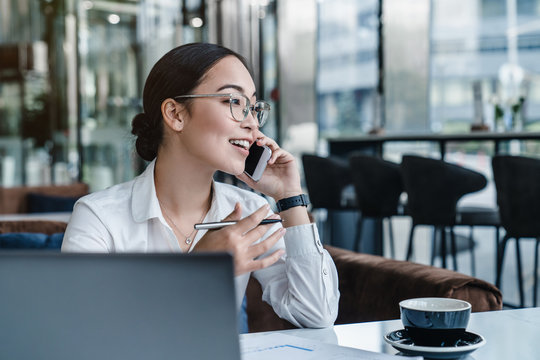 Asian Business Woman Making A Phone Call And Smiling Indoor