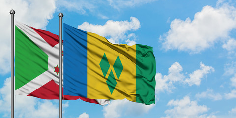 Burundi and Saint Vincent And The Grenadines flag waving in the wind against white cloudy blue sky...