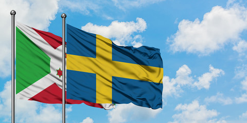 Burundi and Sweden flag waving in the wind against white cloudy blue sky together. Diplomacy concept, international relations.