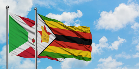 Burundi and Zimbabwe flag waving in the wind against white cloudy blue sky together. Diplomacy concept, international relations.
