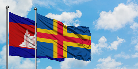 Cambodia and Aland Islands flag waving in the wind against white cloudy blue sky together. Diplomacy concept, international relations.