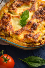 Tasty lasagna, italian cuisine. Pasta. Vertical frame with ingredients. On blue wooden background
