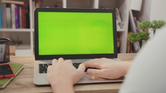 Close up hands man use laptop computer with green screen chroma key display internet business office technology work desk connection keyboard pc device slow motion