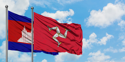 Cambodia and Isle Of Man flag waving in the wind against white cloudy blue sky together. Diplomacy concept, international relations.