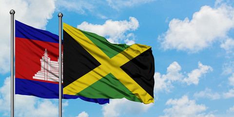 Cambodia and Jamaica flag waving in the wind against white cloudy blue sky together. Diplomacy concept, international relations.