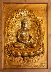 Da Nang, Vietnam - March 10, 2019: Chua An Long Chinese Buddhist Temple. Closeup of framed gold plated image of sitting Buddha.