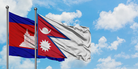 Cambodia and Nepal flag waving in the wind against white cloudy blue sky together. Diplomacy concept, international relations.