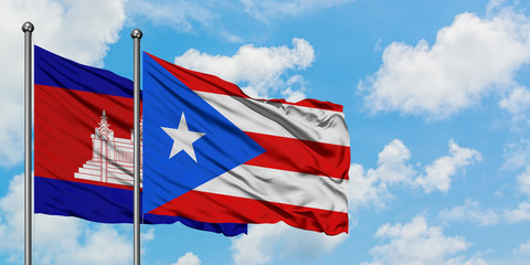 Cambodia and Puerto Rico flag waving in the wind against white cloudy blue sky together. Diplomacy concept, international relations.