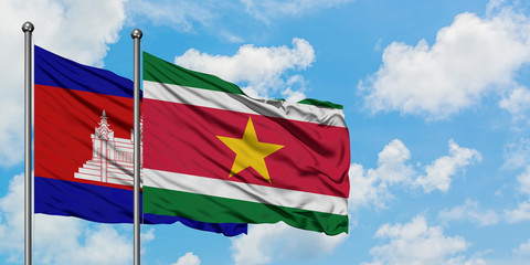 Cambodia and Suriname flag waving in the wind against white cloudy blue sky together. Diplomacy concept, international relations.