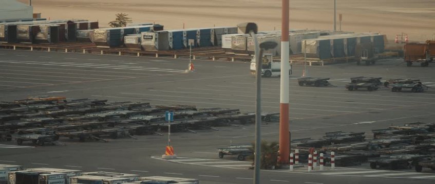Man driving a small service baggage car on a runway of the airport at sunset, BMPCC 4K - cinematic slow motion. Smooth movement, handled, long shot.