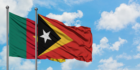 Cameroon and East Timor flag waving in the wind against white cloudy blue sky together. Diplomacy concept, international relations.