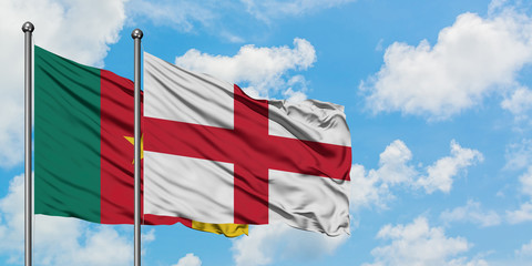 Cameroon and England flag waving in the wind against white cloudy blue sky together. Diplomacy concept, international relations.