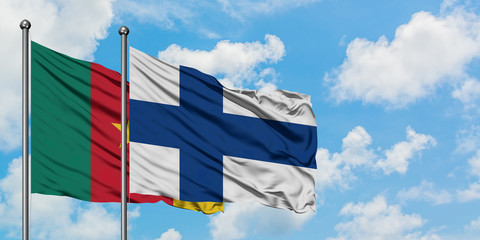 Cameroon and Finland flag waving in the wind against white cloudy blue sky together. Diplomacy concept, international relations.