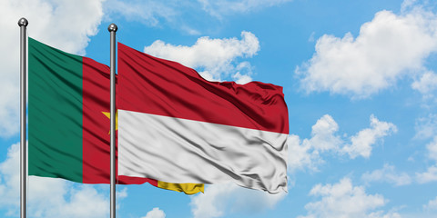 Cameroon and Indonesia flag waving in the wind against white cloudy blue sky together. Diplomacy concept, international relations.
