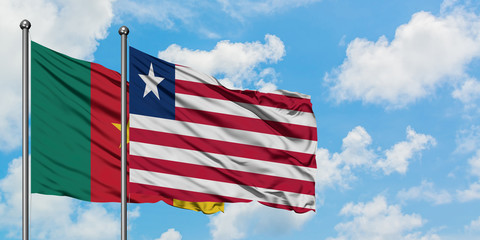 Cameroon and Liberia flag waving in the wind against white cloudy blue sky together. Diplomacy concept, international relations.