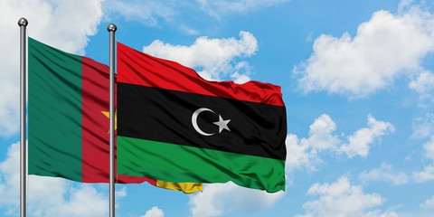 Cameroon and Libya flag waving in the wind against white cloudy blue sky together. Diplomacy concept, international relations.