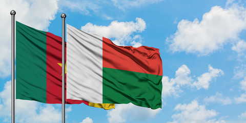 Cameroon and Madagascar flag waving in the wind against white cloudy blue sky together. Diplomacy concept, international relations.