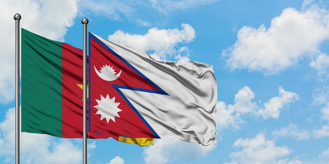 Cameroon and Nepal flag waving in the wind against white cloudy blue sky together. Diplomacy concept, international relations.