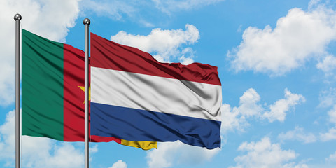 Fototapeta na wymiar Cameroon and Netherlands flag waving in the wind against white cloudy blue sky together. Diplomacy concept, international relations.