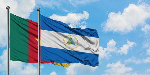 Cameroon and Nicaragua flag waving in the wind against white cloudy blue sky together. Diplomacy concept, international relations.