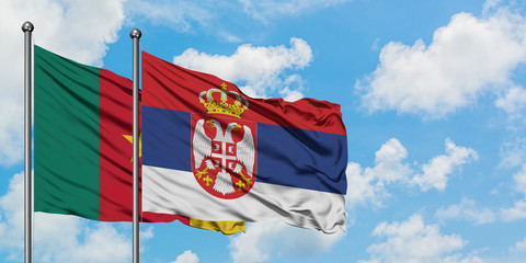 Cameroon and Serbia flag waving in the wind against white cloudy blue sky together. Diplomacy concept, international relations.