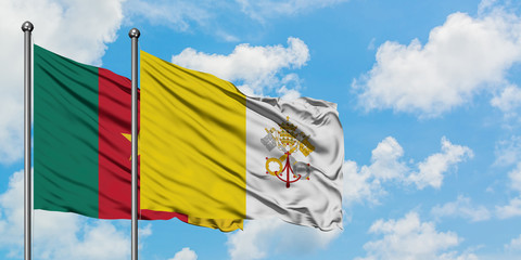 Cameroon and Vatican City flag waving in the wind against white cloudy blue sky together. Diplomacy concept, international relations.