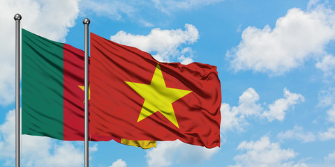 Cameroon and Vietnam flag waving in the wind against white cloudy blue sky together. Diplomacy concept, international relations.