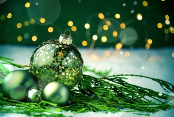 Weihnachtsdekoration oder Hintergrund mit grünen Weihnachtskugeln im Schnee