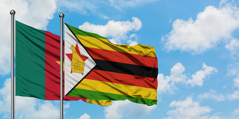 Cameroon and Zimbabwe flag waving in the wind against white cloudy blue sky together. Diplomacy concept, international relations.