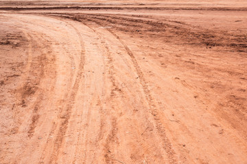 Curved rut background texture on hard dry dirt road