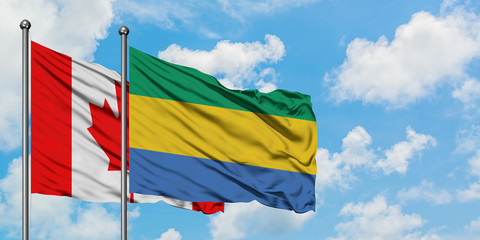 Canada and Gabon flag waving in the wind against white cloudy blue sky together. Diplomacy concept, international relations.