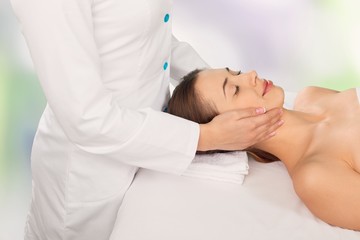 Fototapeta na wymiar Beautiful young woman enjoying head massage in spa center