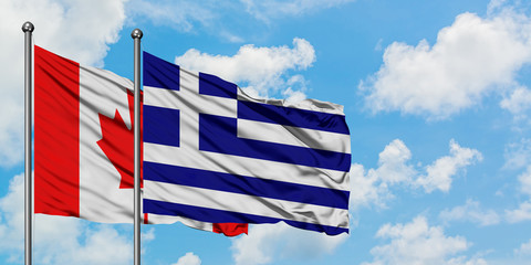 Canada and Greece flag waving in the wind against white cloudy blue sky together. Diplomacy concept, international relations.
